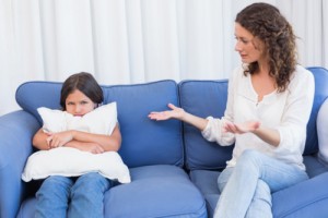 Upset mother looking at her daughter in the living room